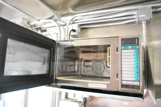 Interior of a microwave in a 2020 Diamond Cargo 24' commercial kitchen trailer, displaying control panel and wiring above.