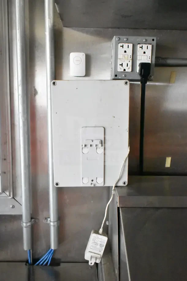 Control panel inside the 2020 Diamond Cargo 24' kitchen trailer, showing electrical outlets and wiring setup.