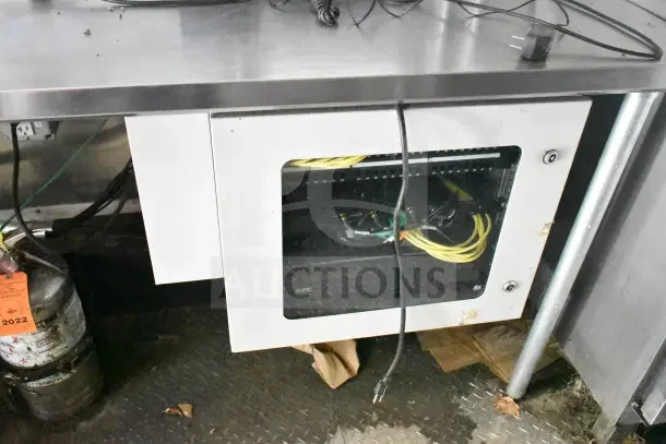 Inside view of 2020 Diamond Cargo 24' kitchen trailer showing stainless steel countertop and wiring panel. Equipment tested.