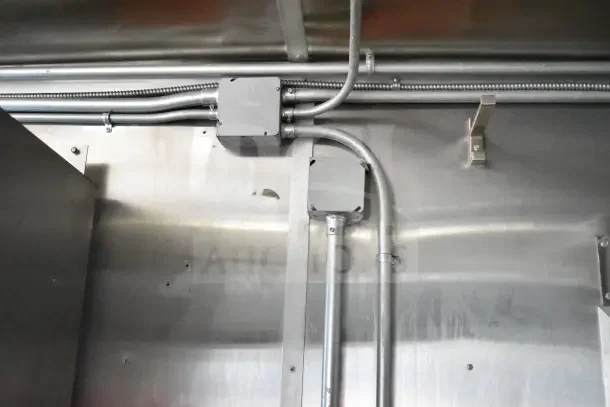 Interior wiring and metal walls of a 2020 Diamond Cargo 24' Commercial Kitchen Trailer, showcasing sturdy construction.