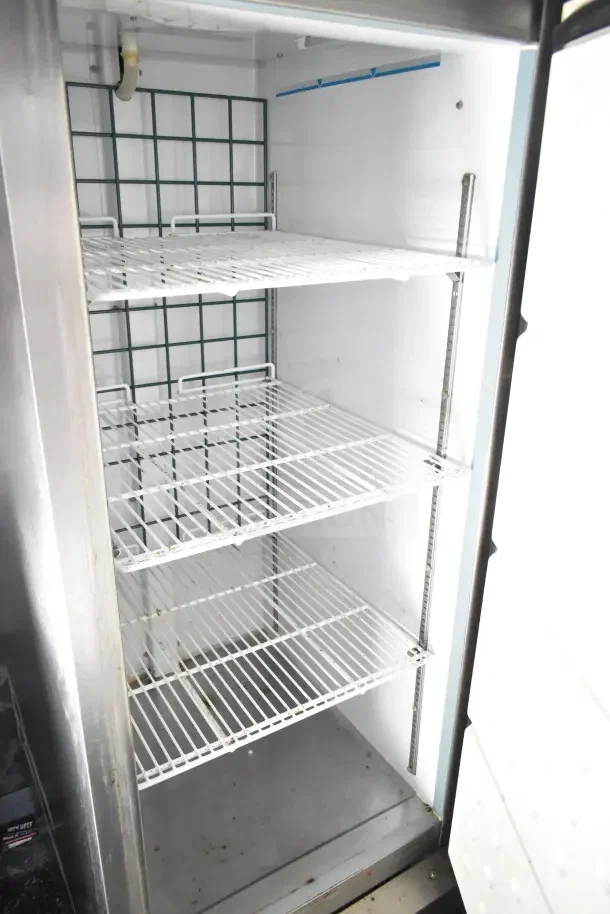 Interior view of Arctic Air Refrigeration unit with clean metal shelves inside the 2020 Diamond Cargo kitchen trailer.
