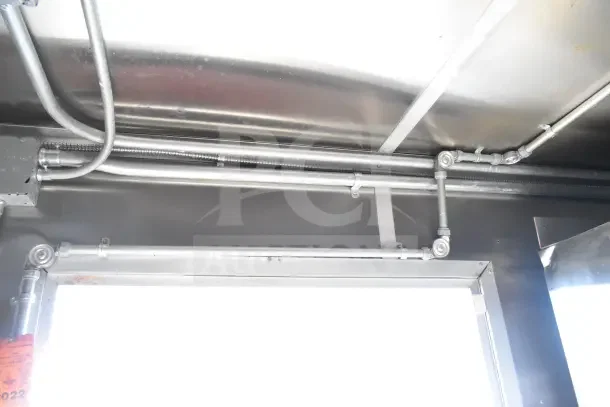 Interior view of 2020 Diamond Cargo commercial kitchen trailer, showing metal piping and wiring setup.
