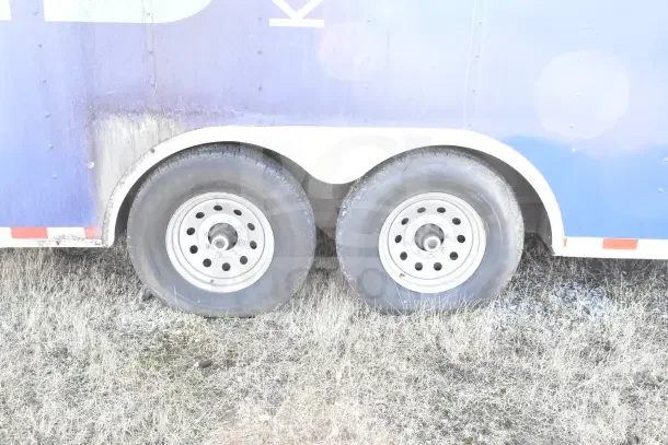 Dual axle wheels of a 2020 Diamond Cargo 24' commercial kitchen trailer, shown on grass.