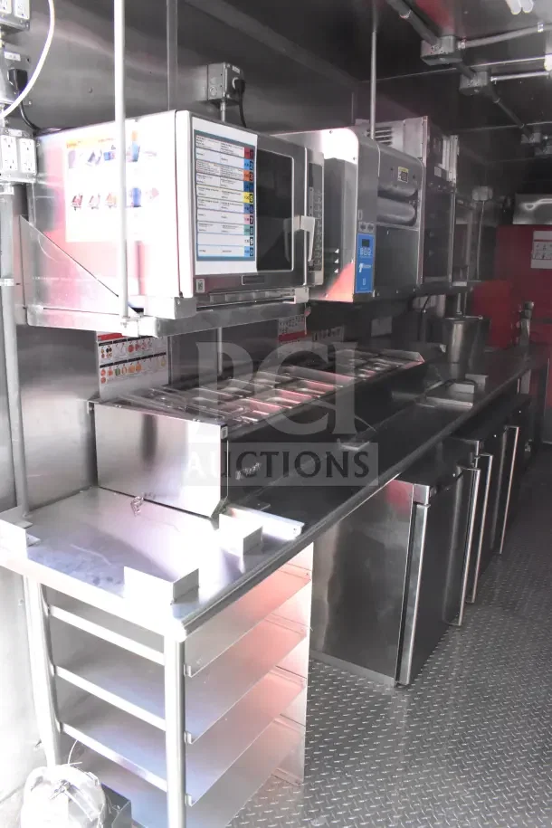 New 2022 Rock Solid Cargo 8.5x28 ghost kitchen trailer with SaniServ shake machine, Henny Penny fryer, Garland griddle, and refrigeration suite.