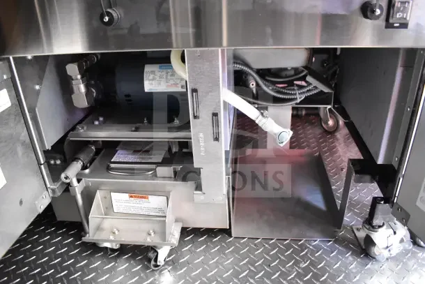Interior view of Rock Solid Cargo Ghost Kitchen Trailer components, including machinery and fittings on diamond plate flooring.