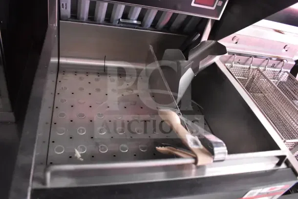 Interior of a 2022 Rock Solid Cargo kitchen trailer featuring a Henny Penny EEG-253 propane fryer with basket and tongs.