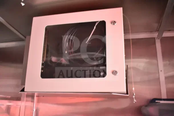 Wall-mounted electrical panel in a 2022 Rock Solid Cargo 8.5x28 Ghost Kitchen Trailer. Panel is secured and contains coiled cable.