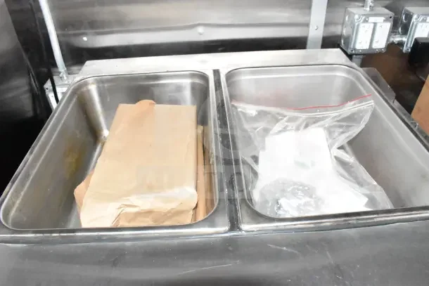 Stainless steel bins inside a 2022 Rock Solid Cargo Ghost Kitchen Trailer, showcasing interior storage.
