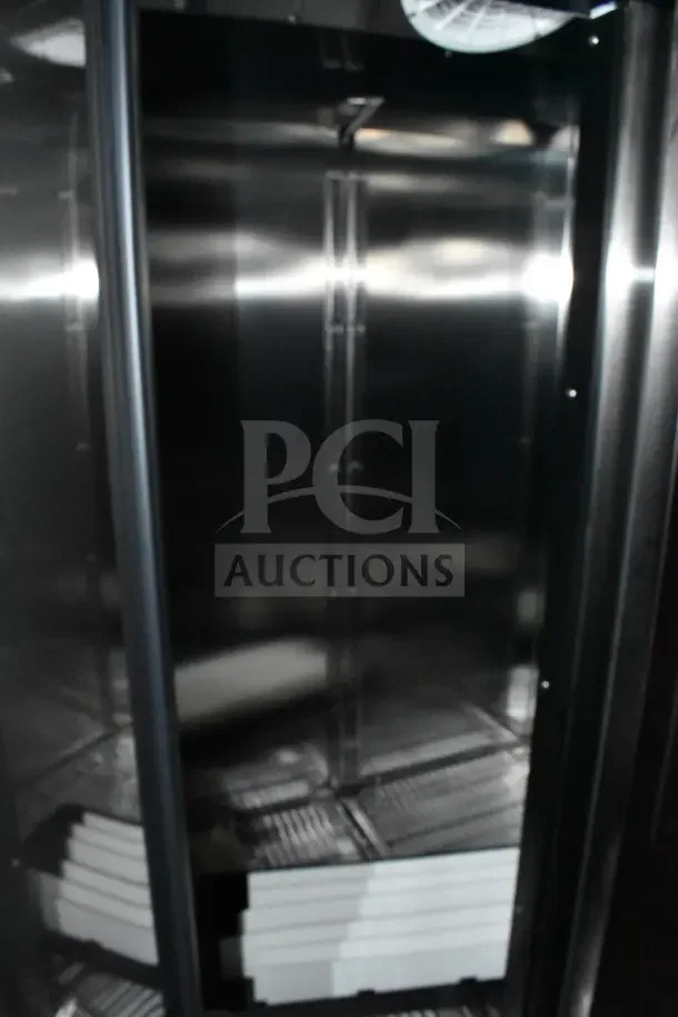 Interior of 2022 Rock Solid Cargo Ghost Kitchen Trailer with stainless steel walls and storage shelves, in new condition.