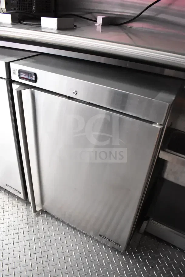 Rock Solid Cargo kitchen trailer interior showing Hoshizaki refrigerator with stainless steel finish, in new condition.
