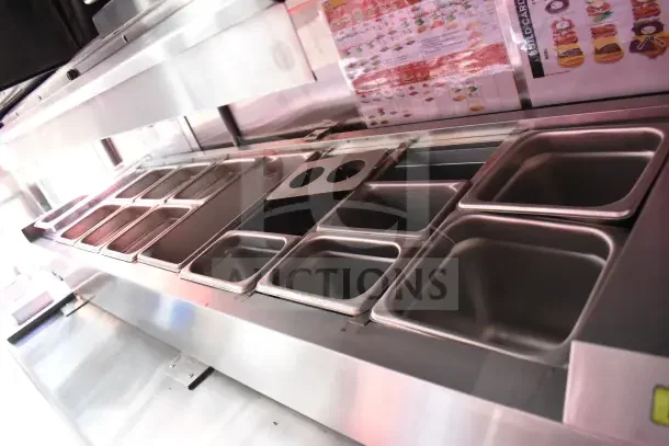 Rock Solid Cargo 8.5x28 ghost kitchen trailer interior showing stainless steel prep area with food pans and menu display.
