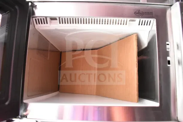 Interior view of a stainless steel appliance in the Rock Solid Cargo kitchen trailer showing clean, unused condition.