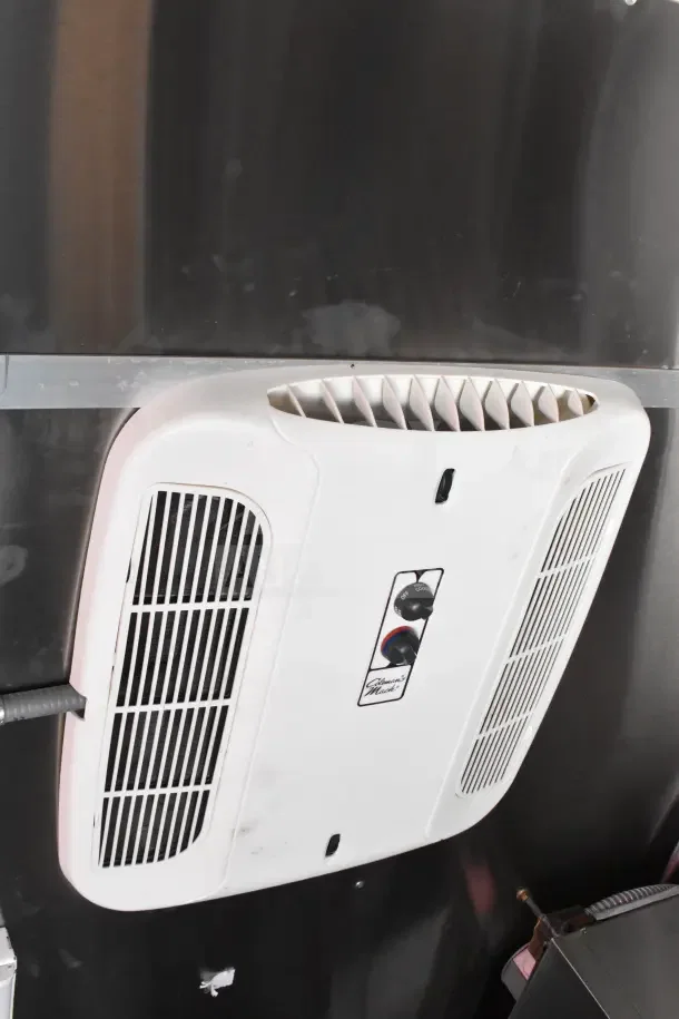 Ceiling-mounted white air conditioning unit in Rock Solid Cargo ghost kitchen trailer, temperature controls visible.