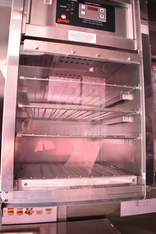 Interior of a Henny Penny fryer in a 2022 Rock Solid Cargo ghost kitchen trailer, showing racks and control panel with Wendy's logo.
