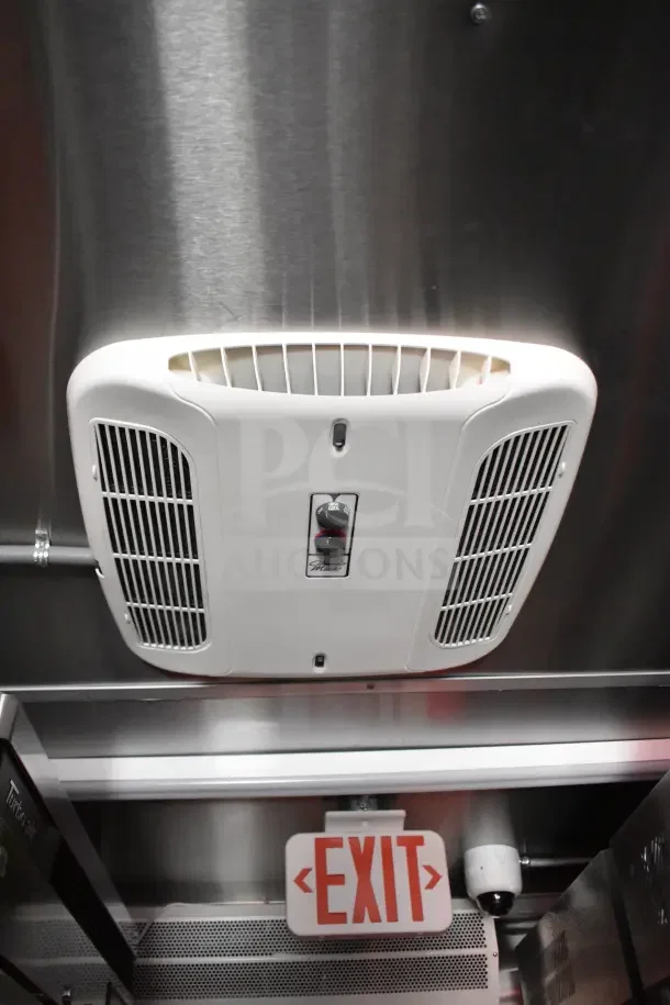 Interior of 2022 Rock Solid Cargo kitchen trailer showing ventilation system, Turbo Air refrigeration, and exit sign.