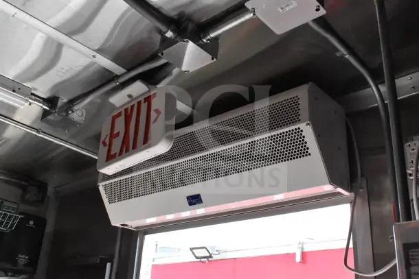 Interior view of the 2022 Rock Solid Cargo Ghost Kitchen Trailer, showing exit sign and air curtain for ventilation.