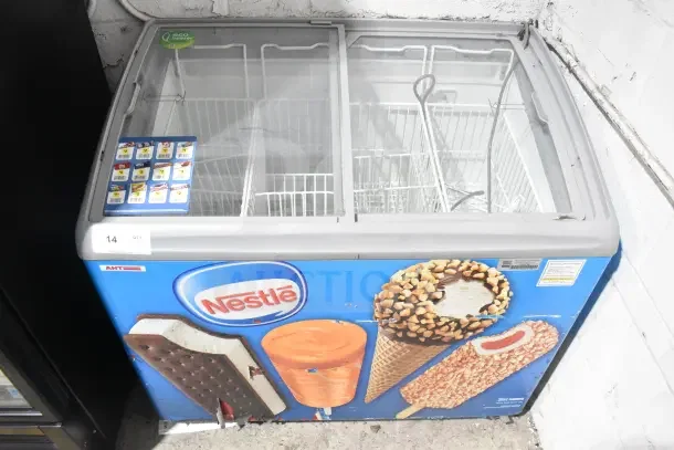AHT RIO S commercial chest freezer with sliding doors, Nestlé branding, 115V, 1 phase, on casters. Used condition.