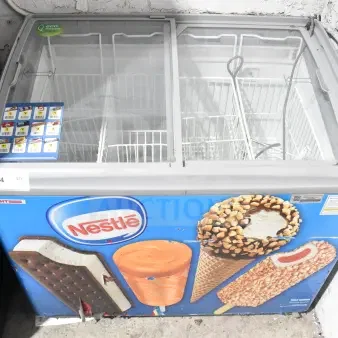 AHT RIO S commercial chest freezer with sliding doors, Nestlé branding, 115V, 1 phase, on casters. Used condition.