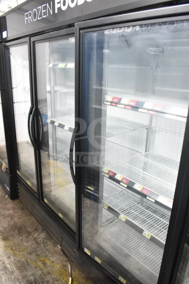 2018 True GDM-72F-HC commercial 3-door freezer, black frame, glass doors, labeled "Frozen Foods," tested, working.
