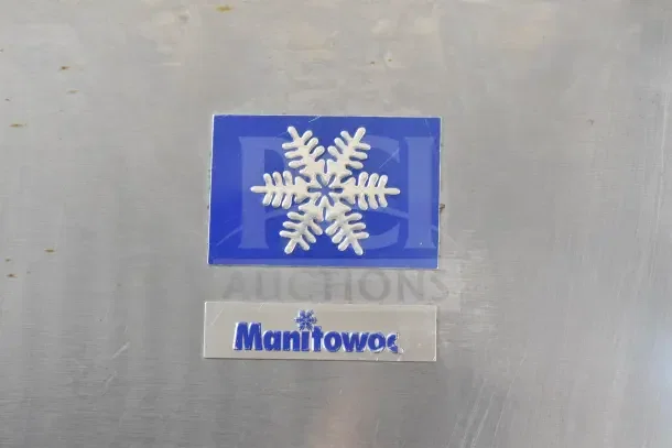 Manitowoc SY0874C commercial ice machine with ice bin, featuring brand logo and snowflake design on stainless steel surface.