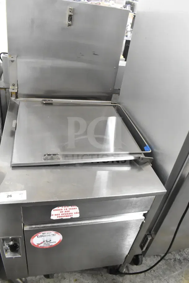 Commercial floor-style donut fryer, stainless steel, top view with closed lid. Warning labels visible, good condition.