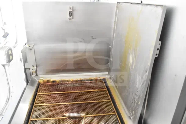 Commercial floor-style donut fryer, stainless steel construction, showing used condition with grease buildup on surfaces.