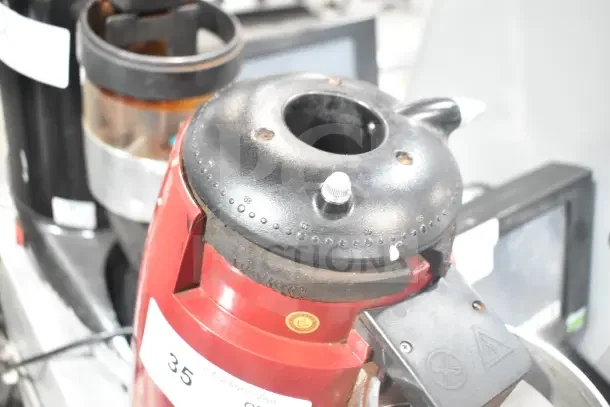 Wega commercial countertop espresso bean grinder base, 115 volts, 1 phase, red casing. Used condition, visible wear.