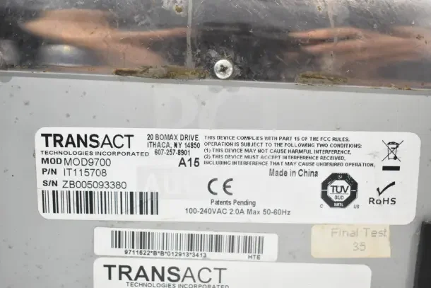 Transact Ithaca 9700 food prep labeler model MOD9700, serial ZB005093380. Labels indicate FCC compliance and RoHS certification.