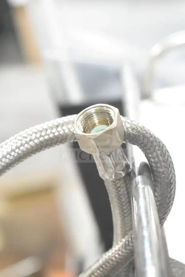 Close-up of a braided metal hose and fitting for a Schaerer SCA1 Coffee Art Commercial Espresso Machine.