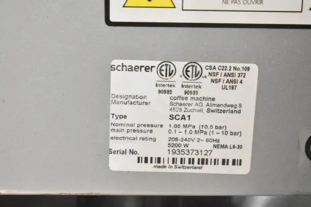 Schaerer SCA1 Coffee Art espresso machine label showing model, electrical specs, and pressure details.