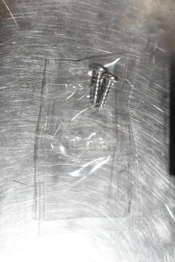 A small plastic bag containing screws, likely included as installation hardware for the Insinkerator HWT Instant Hot Water Tank.