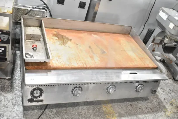 Star commercial countertop flat top griddle with thermostatic controls. Used condition, rust on surface, 4 dial controls visible.