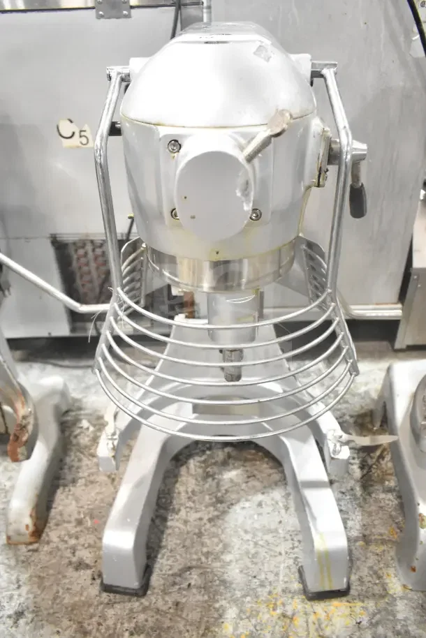 M20A Commercial 20L countertop planetary dough mixer with bowl guard, 110V, 1 phase. Visible wear and sturdy construction.