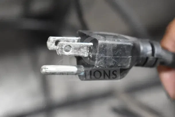 Black three-prong power plug of Berkel PM-2B commercial dough mixer, 110 Volts, shown against a blurred background.