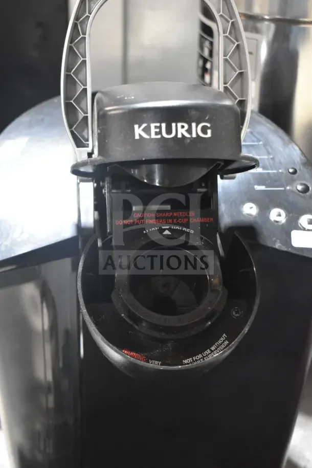 Keurig K40 single cup coffee machine, visible caution label, black finish, includes pod holder; bid doubles the quantity.