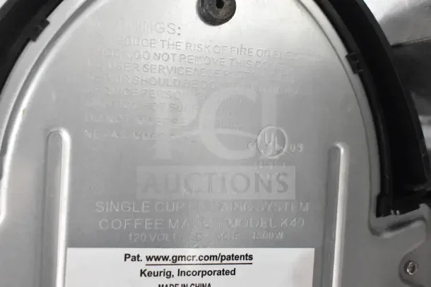 Keurig K40 coffee machine base with model info and safety warnings etched; includes single cup brewing system details.