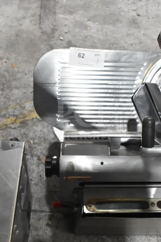 Globe 775L commercial meat slicer with blade sharpener, 115V, stainless finish, countertop model, auction tag visible.