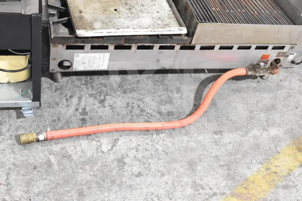 Prince Castle FHP48-2RB countertop gas charbroiler with 4-burner range, used condition, visible gas connection.