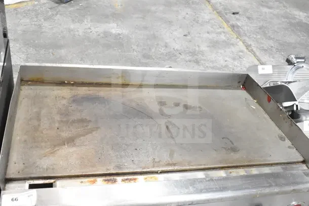 Wells Commercial Countertop Gas Flat Top Griddle, used condition, visible surface wear, stainless steel, auction tag attached.