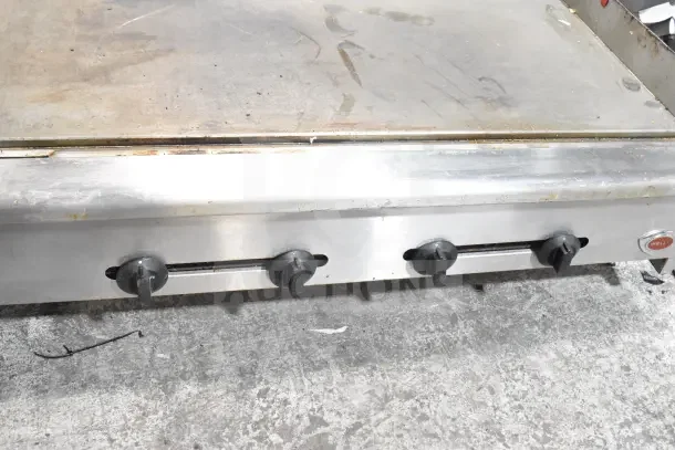 Wells Commercial Gas Flat Top Griddle with four control knobs, used condition, stainless steel, countertop model.