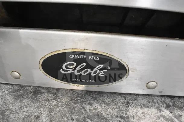 Globe 500L Commercial Meat Slicer, stainless steel, with blade sharpener. Features "Gravity Feed" label, made in USA.