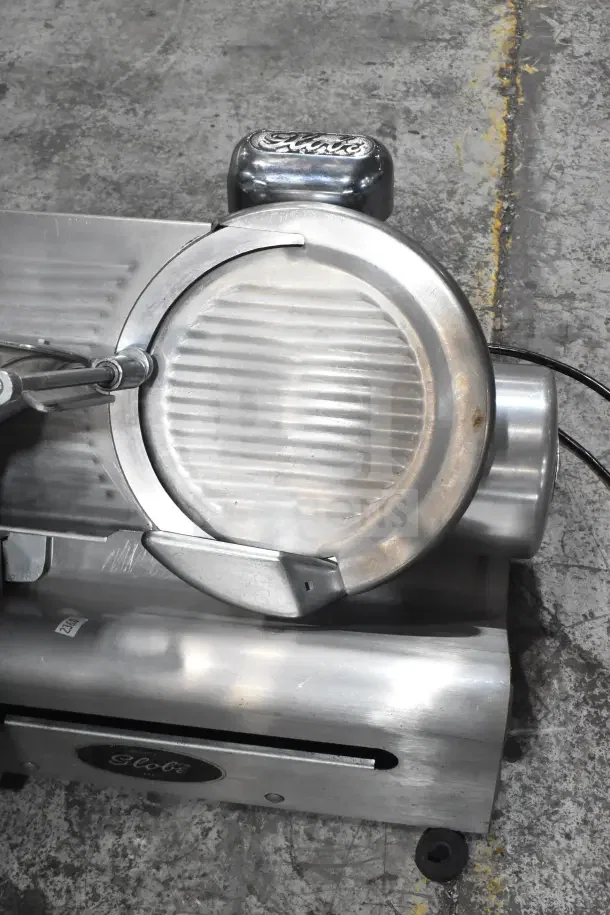 Globe 500 commercial countertop meat slicer, features a blade sharpener, 115 volts, 1 phase, metallic finish, good condition.