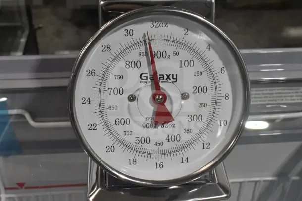 Brand new Galaxy 177GPCM2 2 lb. mechanical portion control scale with scratch and dent, clear dial readings, brand logo.