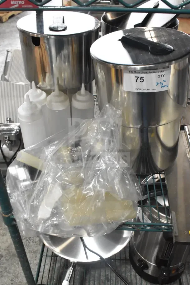 Seven stainless steel condiment bottles and pumps on a shelf. Includes plastic bottles. Auction label visible, lot 75.