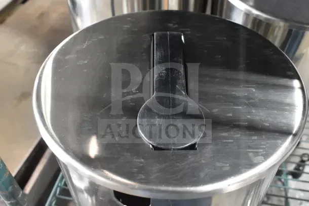 Stainless steel condiment pump with handle, part of a 7-item auction lot, showing slight wear.