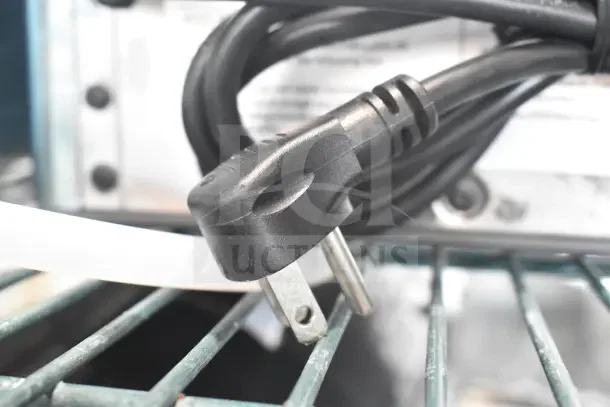 General Electric XPIO13SCBSS ice maker power cord and plug on metal shelving.