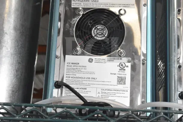 General Electric XPIO13SCBSS ice maker; 3 lbs. capacity, daily production 38 lbs., 120V. Model and serial tags visible.
