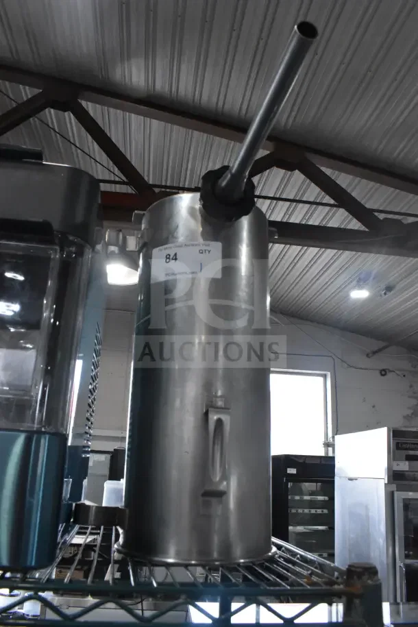 Vegetable chute with pusher for meat slicer, stainless steel, vertical design. Shows auction label number 84, good condition.
