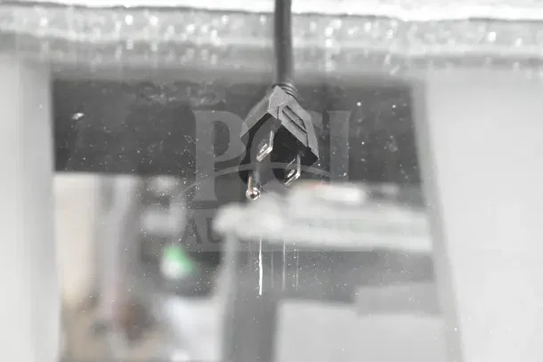 Alt text: Close-up of a power plug for the Avantco 193CAC60B refrigerated air curtain merchandiser. Glass shows scratches.