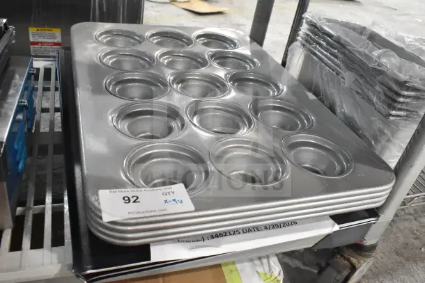 Chicago Metallic 45435 15-cup Jumbo Muffin Pan, aluminized steel, glazed finish, new with tags, stacked on shelf.